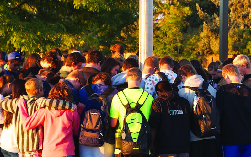 Students circling for prayer after suffering through pandemic