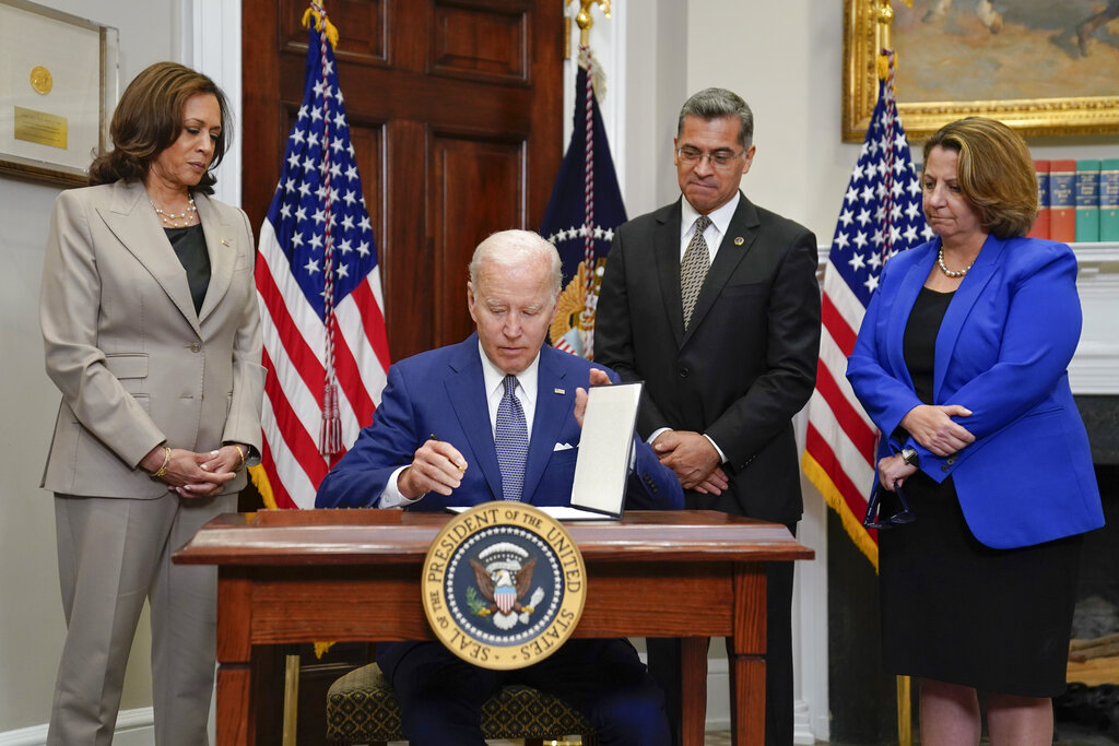 Under pressure to act after Dobbs ruling, Biden signs his name