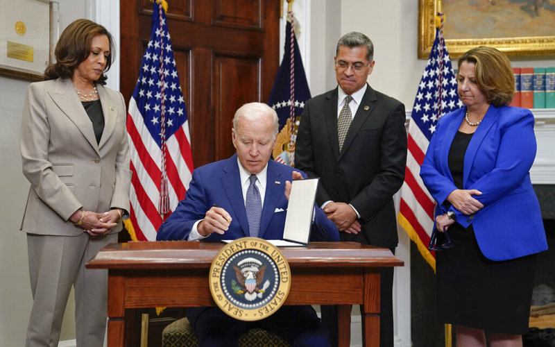 Under pressure to act after Dobbs ruling, Biden signs his name